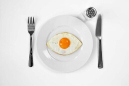 spiegelei in augenform auf teller spiegeleye eierbratring für spaß beim essen fried egg sunny side up eye shape on a plate for kitchen fun